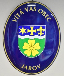 Smaltovaný ovál s vítacím textem, znakem a názvem obce Jarov.