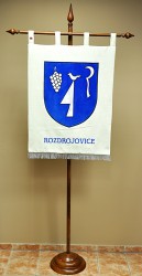 Vyšívaný znak obce Rozdrojovice ve velkém provedení vyvěšený na žerdi tvaru T.