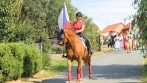 V čele průvodu šel šampion mezi koňmi ve státních barvách s vlajkonoškou, která nesla symbol české státnosti – českou státní vlajku. 