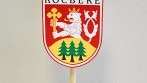 Stolní vlaječka obce Kocbeře vyvěšena na dřevěném stojánku.